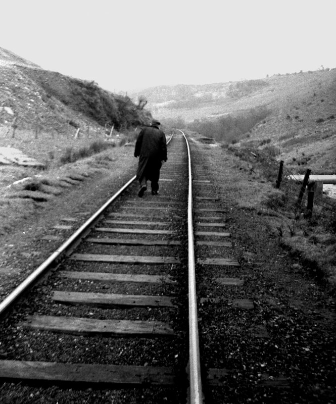 The last colliery railway, near Maesteg, Wales. With a colleagueI had hitched a ride in the cab of the steam engine being used to clear equipment from the closed mine. The man had walked towards us along the track as we were talking to a woman living nearby. He stopped to chat and pose for photographs but as is often the case a better image occurred as he walked home.   